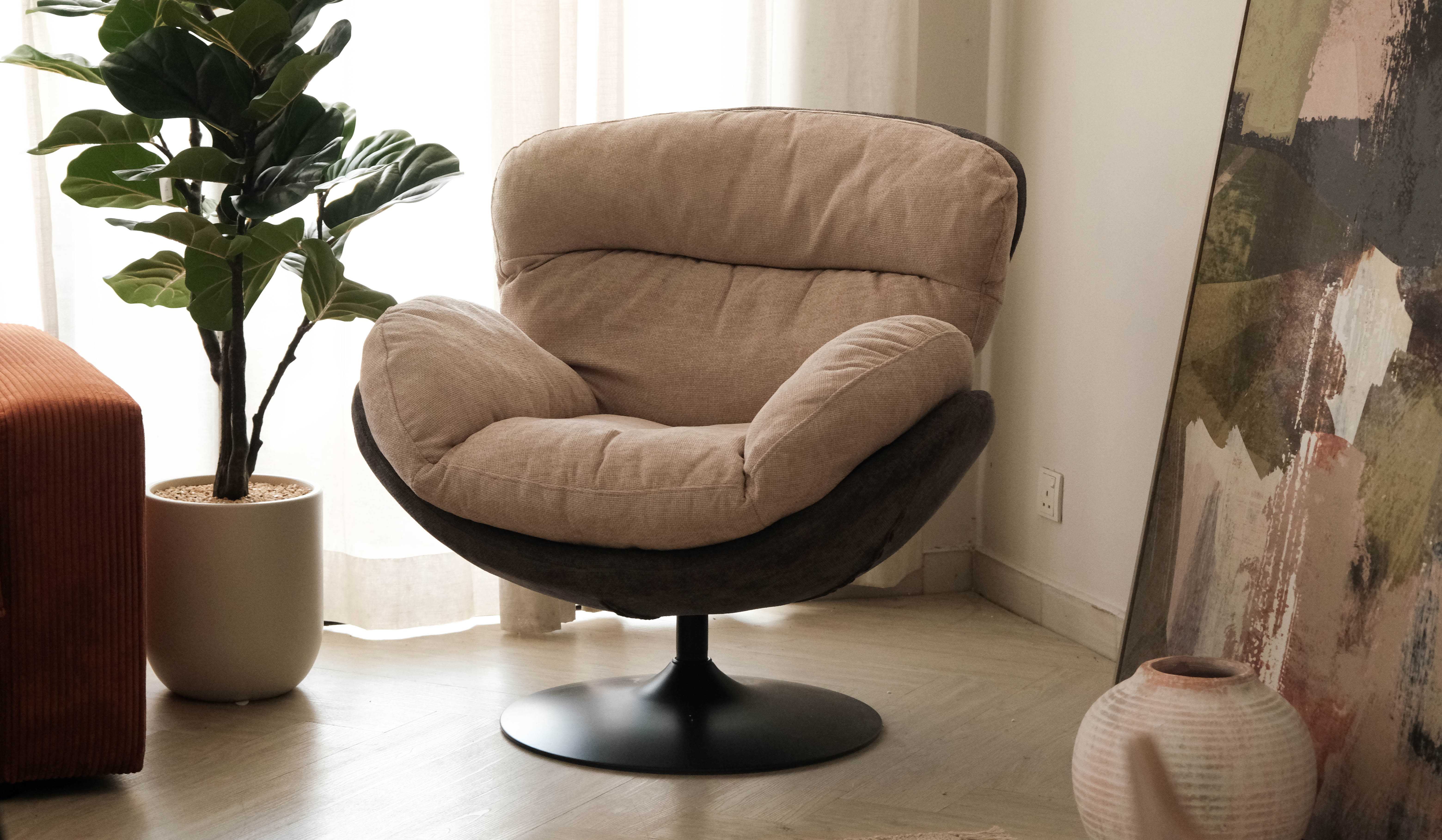 Swivel fabric lounge chair in a cosy reading corner for Malaysian and Singaporean homes