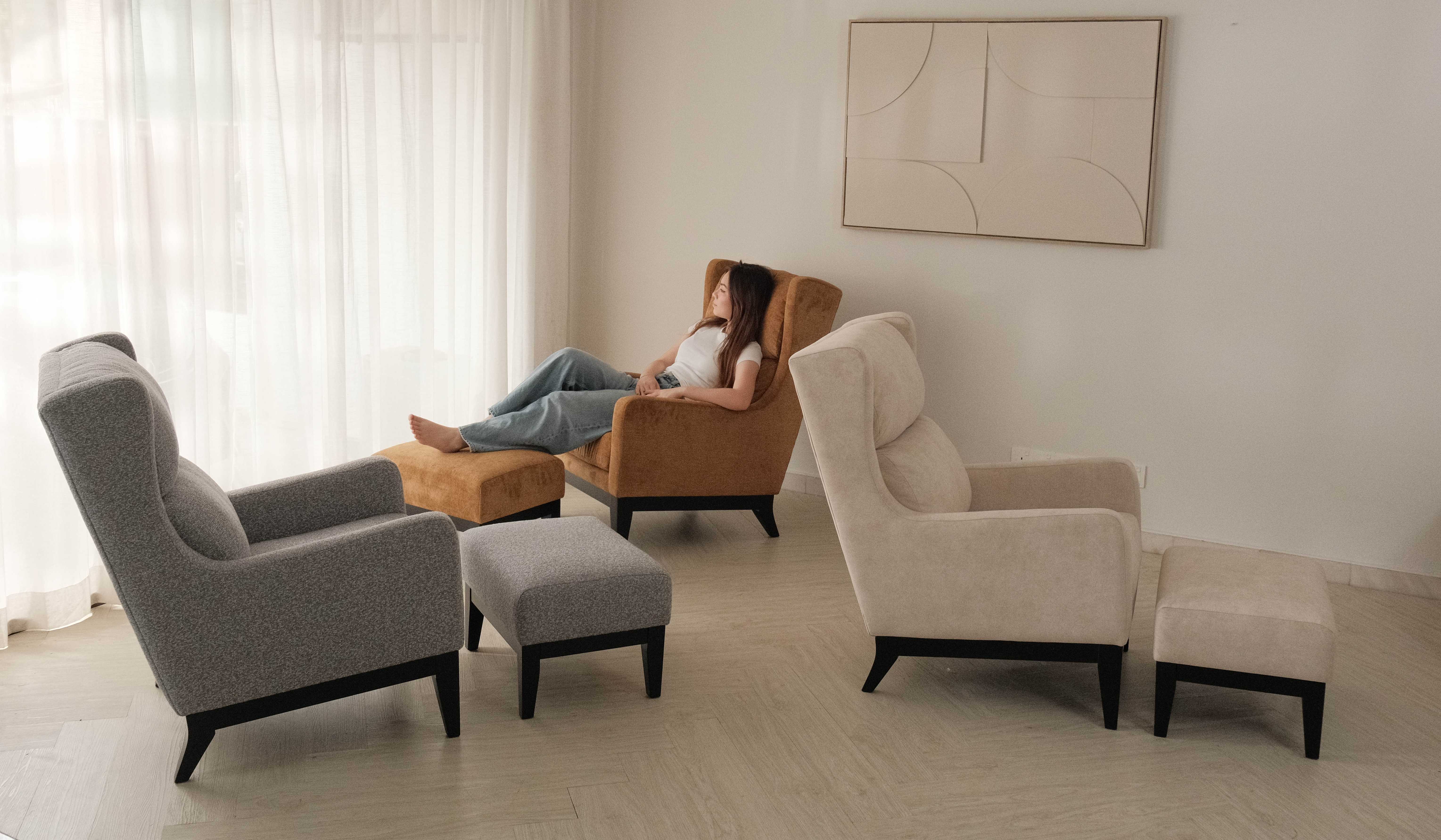 Fabric lounge chairs with ottomans in a bright living room for Malaysian and Singaporean homes
