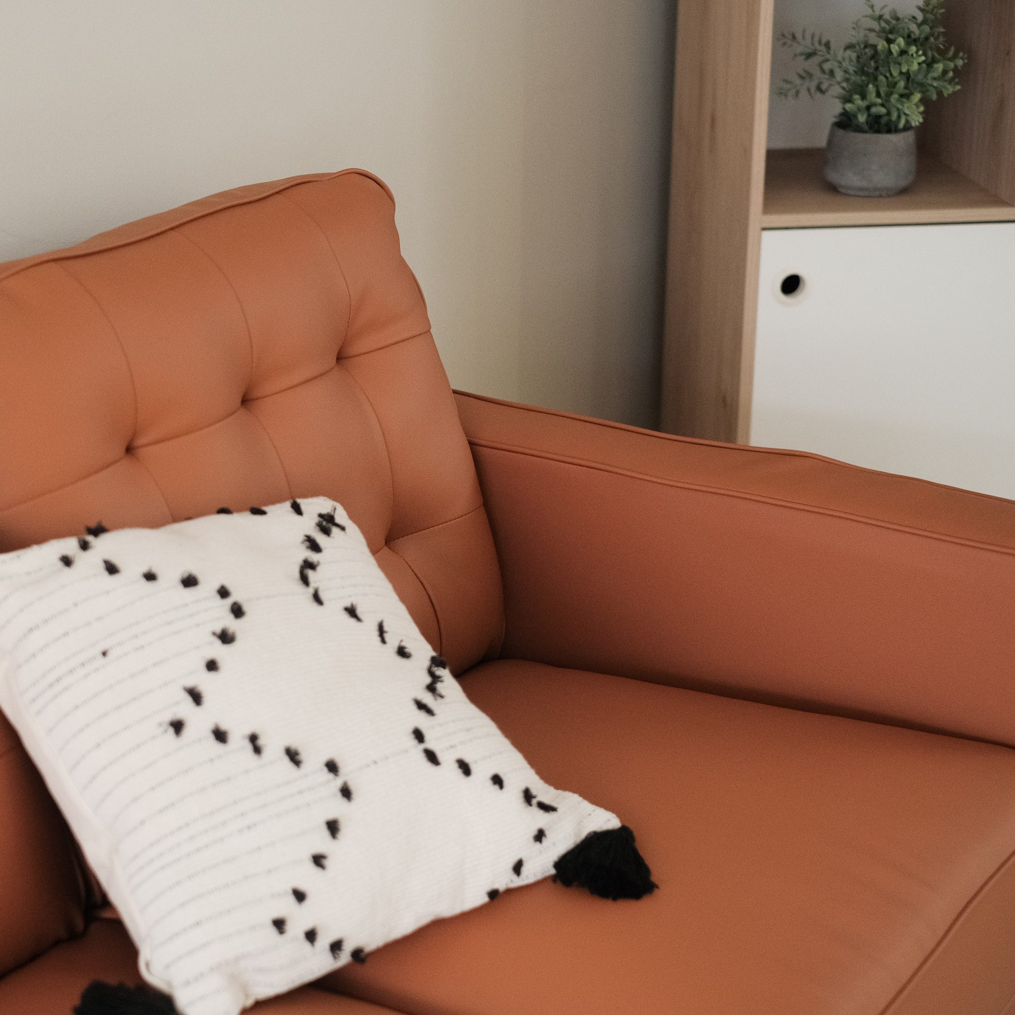 Close-up of the Jane Persimmon sofa upholstery, tufted back cushion and armrest